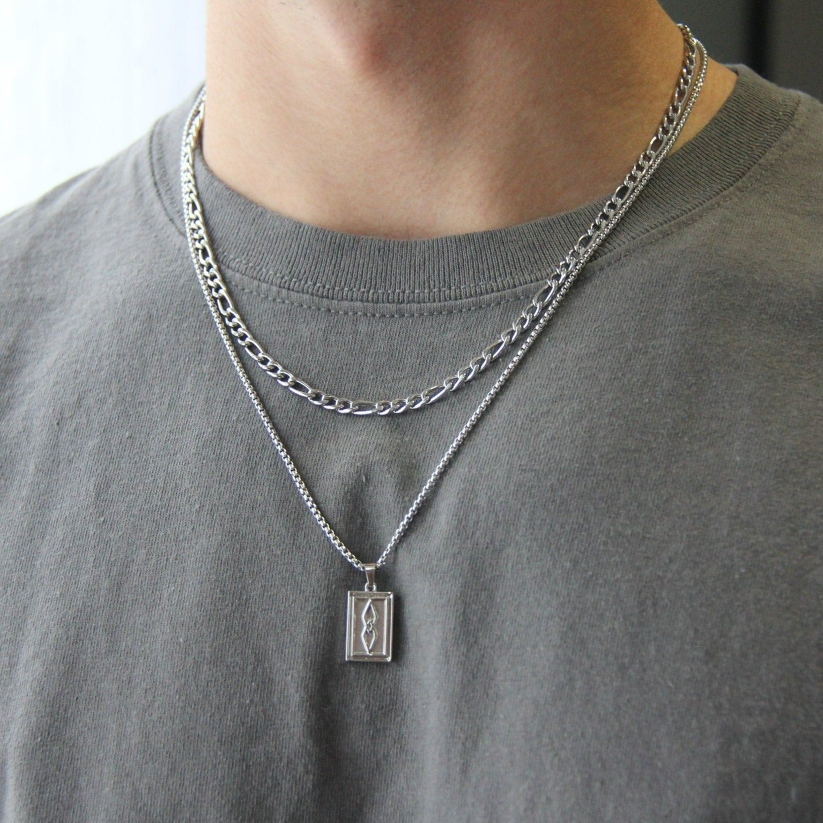 http://wearrenn.com/cdn/shop/products/silver-rectangle-pendant-and-45mm-figaro-chain-necklace-set-for-men-boutique-wear-renn-290711.jpg?v=1689276504